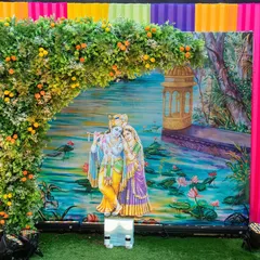 This beautiful photo booth features a serene Radha-Krishna painting as the backdrop. We framed it with a lush floral arch and colorful drapery, providing a divine setting for guests to capture memories at the Hiravati Banquet event.