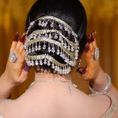A detailed shot of the elegant bridal bun. Notice the clean sections and the beautiful placement of the hair accessory.
