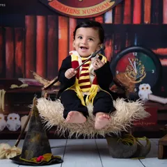 A touch of magic makes everything better. Here, a baby enjoys a levitation spell on a broomstick, set against a backdrop that looks straight out of the movies.