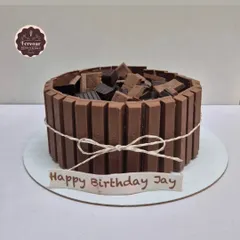 A classic Kit Kat cake. The sides are lined with Kit Kat bars, and the top is filled with chopped chocolate, making it a crunchy, chocolatey dream.