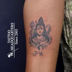 A classic Shiva tattoo featuring the trishul, serpent, and crescent moon. This piece includes the Om and Swastika symbols, representing divinity and good fortune.