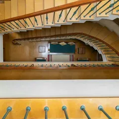 A gracefully curving staircase creates a dramatic vertical space within the home. Viewed from the top, it reveals how open planning connects multiple levels, with natural light from above illuminating the entire core of the house.
