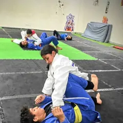 This is where the "gentle art" of Brazilian Jiu-Jitsu begins. A young student learns to control her opponent from the mount position, a foundational skill in grappling that teaches leverage over strength.