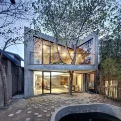 This modern home was designed to fully embrace the tree growing through its center. The large glass windows and open courtyard design make the tree a focal point from both inside and out, showcasing a perfect blend of nature and architecture.