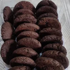 A fresh batch of my sugar-free chocolate cookies, neatly packed and ready for delivery. Their rich, dark color comes from the wholesome ingredients I use.
