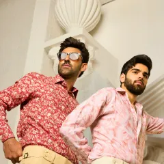 Florals, refined. This image showcases two of my printed linen shirts, one in a subtle red and beige floral and the other in a pink abstract pattern, both paired with tailored trousers for an elevated casual style.