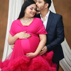 A classic couple's portrait filled with warmth and affection. The partner's gentle embrace from behind provides a sense of love and security, making for a cherished pregnancy memory.