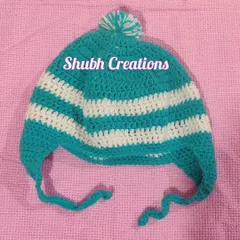 A close-up of the teal and white striped baby hat with earflaps and a pom-pom, part of a complete winter set.