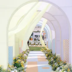 A whimsical spring palette on a summer afternoon. This arched walkway, with its checkered patterns and flowing drapes, led to a custom-designed bar inside a VW bus, all tied together with a garden of yellow flowers.