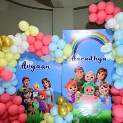 Another angle of the Cocomelon party, showing the two personalized backdrops for each birthday child.
