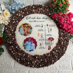 The border of this love story frame is made from the preserved engagement garlands of the client's brother, making it an incredibly personal wedding gift.