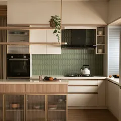 The kitchen in this villa balances bold geometry with natural grace. I used olive green tiles for a pop of color, framed by reeded glass and warm wood cabinetry, with a floating shelf that adds architectural interest.