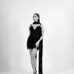 A full-length monochrome portrait from the same series, showcasing the classic silhouette of the little black dress against a clean white background.