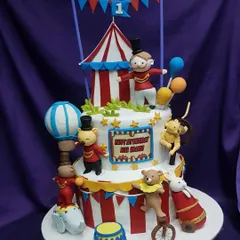 Welcome to the carnival! This two-tier circus cake is full of fun, featuring a ringmaster, performing animals, and a classic red-and-white striped tent. It's a vibrant and exciting centerpiece for a child's birthday.