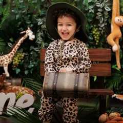 Our little explorer, ready for a jungle adventure! Dressed in a leopard print outfit, he's all smiles in our lush jungle-themed first birthday set.