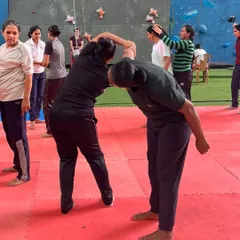 Partner drills are essential for learning how to react to an opponent. In this image, participants practice escaping a hold, learning to use leverage and body mechanics to break free from a stronger grip.