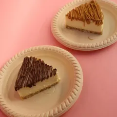 A perfect pairing of our most popular eggless cheesecakes. On the left, a slice of rich Nutella cheesecake, and on the right, the irresistibly crunchy and spiced Lotus Biscoff cheesecake.
