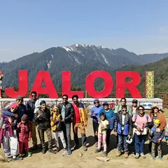 Posing at the famous Jalori Pass sign, a high-altitude mountain pass we cross on our Jibhi & Tirthan Valley trip.
