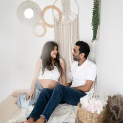 A relaxed and happy moment in our boho-inspired studio corner. This shot captures the casual, fun side of a couple's maternity session.