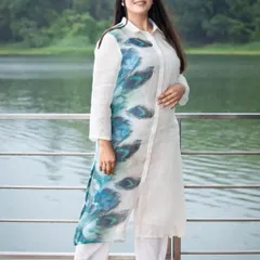 An image from a fashion catalogue shoot featuring a model in a white and blue printed kurta. The lakeside background complements the colors of the outfit.