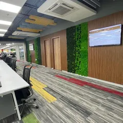This long corridor in a busy office is broken up by panels of preserved moss set against wood-paneled walls. This design adds visual interest and a touch of nature, improving the experience of walking through what would otherwise be a purely functional space.