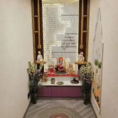 A wider view of the completed mandir, showing the herringbone-patterned flooring and the circular jute rug that grounds the sacred space.