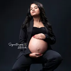 A seated portrait that feels both strong and serene, focusing on the beautiful shape of the baby bump.