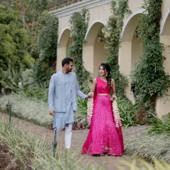 A couple walking hand-in-hand through the beautiful gardens of Sula Vineyards. This shot captures a relaxed moment against a lush, scenic backdrop.