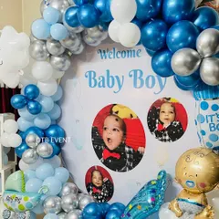 A closer look at the personalized "Welcome Baby Boy" backdrop. Including pictures of the little one makes the decoration feel so much more special and unique.
