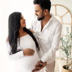 Maternity sessions are even more special when your partner joins in. This intimate moment shows a couple sharing a loving gaze, celebrating their journey to parenthood together in my bright and airy studio.