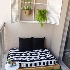 This cozy corner features a low pallet seating base with a comfortable custom mattress, creating a perfect spot for lounging. The look is completed with a decorative window frame.