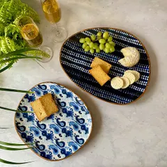 Inspired by the rich artistry of Indonesian craft, our Bali Collection features exquisite Batik patterns on handcrafted mango wood plates. These organic-shaped platters are perfect for serving cheese and crackers with island flair.