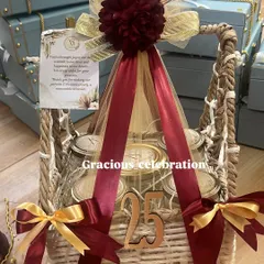 Celebrating a 25th anniversary is a grand affair, and the return gifts should be just as special. This luxurious basket hamper, decorated in rich maroon and gold, is filled with five different jars of delicious eatables and marked with a '25' to honor the silver jubilee.