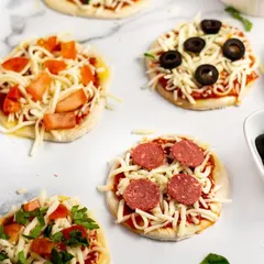 For cocktail parties or as appetizers, I offer these mini pizzas with a variety of toppings like pepperoni, black olives, and fresh vegetables. They are easy for guests to enjoy while mingling.