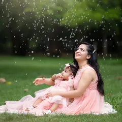 A mother and daughter enjoy a shower of bubbles during their outdoor session. Using simple props like bubbles is a great way to get genuine smiles from children.