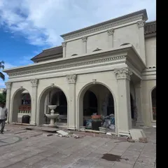 The exterior of the Veerabhavana Villa under construction, showing the grand arches and classical columns that define its Mediterranean architectural style. The use of stone cladding gives the home a sense of permanence and grandeur.