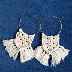 For those who love a bohemian touch, I create these macrame hoop earrings. I use classic macrame knots and finish them with a soft fringe, all attached to a simple hoop. They are a beautiful example of wearable fiber art.