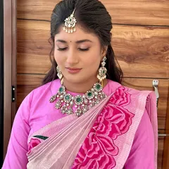 A close-up on the soft pink eye makeup, paired with a beautiful emerald and diamond necklace.