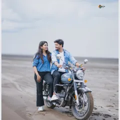 A relaxed and happy portrait of a couple on a Royal Enfield at the beach, capturing a perfect blend of adventure and romance for a casual pre-wedding shoot.