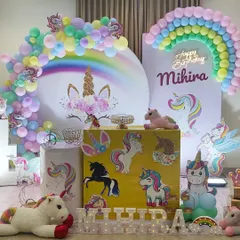 A close-up of the main unicorn backdrop, featuring a neon "Happy Birthday" sign and a rainbow balloon arch.