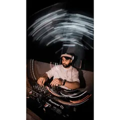An artistic shot with light trails, showing the dynamic nature of a live DJ performance. It's all about creating movement and energy through sound.