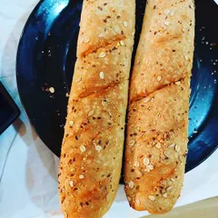 Freshly baked multigrain baguettes made by students in our baking diploma course. We focus on teaching the fundamentals of artisan bread making, a key skill for any professional bakery.