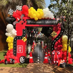 Welcome to the fast lane. This grand entrance arch for a Ferrari-themed birthday party sets the high-energy tone from the moment guests arrive, complete with a custom racetrack walkway and racing-inspired balloon garlands.