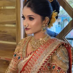 A close-up of a stunning Maharashtrian bride, highlighting the detailed makeup, traditional nath, and elaborate gold jewellery.