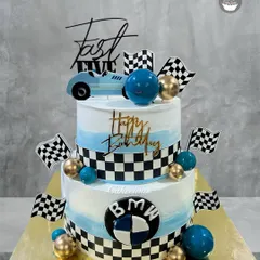 For the ultimate speed lover, I designed this two-tier BMW-themed birthday cake. It features a blue and white ombre design, checkered racing flags, and the iconic BMW logo, making it a perfect centerpiece for a car-themed party.