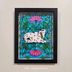 This framed Pichwai-style cow, painted on glass, is surrounded by lotuses. The glass medium gives the colors a special luminosity, making it a vibrant addition to any wall.