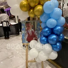 A personalized welcome easel is a lovely way to greet guests. Here, I framed a photo of the baby with a cascade of blue, white, and gold balloons.