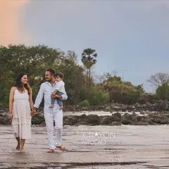 A quiet walk along the shoreline as the sun begins to set. This wide shot captures the peaceful atmosphere of the beach and the simple, beautiful moment of a family enjoying time together.
