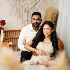 A beautifully framed shot of the couple, with pampas grass in the foreground. This creative composition adds depth and a soft, dreamy quality to the maternity portrait.