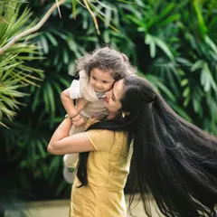 This mother-daughter portrait is full of movement and life. The mother's long hair flowing in the wind as she holds her child creates a stunning and artistic image that feels both candid and timeless.